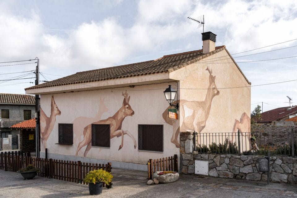 a mural of deer prancing on the side of a building